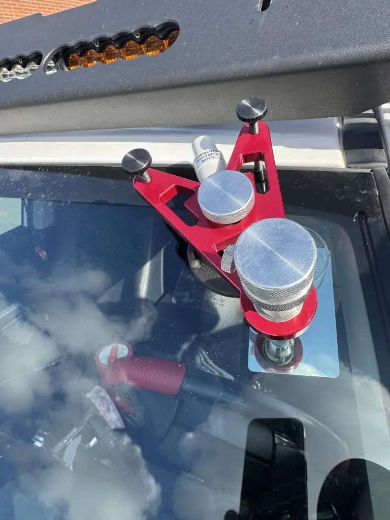 Windshield crack repair tool setup on a vehicle during a mobile appointment